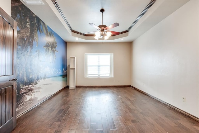 spare room with ceiling fan, a tray ceiling, ornamental molding, and hardwood / wood-style flooring