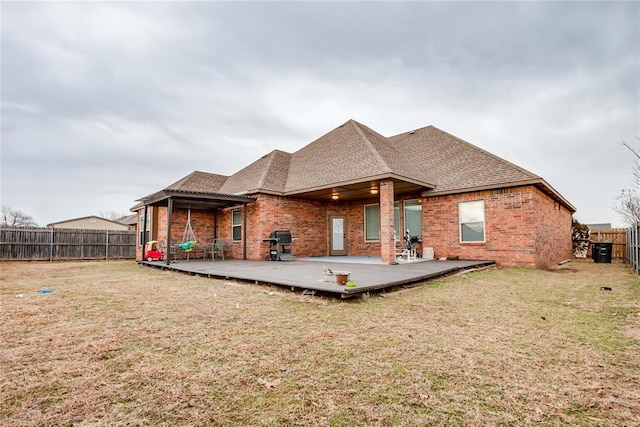 rear view of house with a wooden deck and a yard