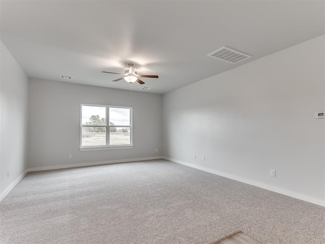 unfurnished room featuring light carpet, ceiling fan, visible vents, and baseboards