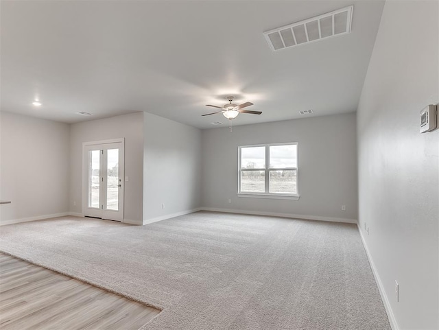 spare room featuring baseboards, visible vents, and a wealth of natural light