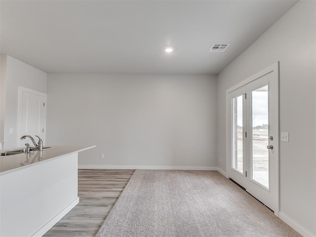 unfurnished dining area featuring recessed lighting, visible vents, a sink, and baseboards