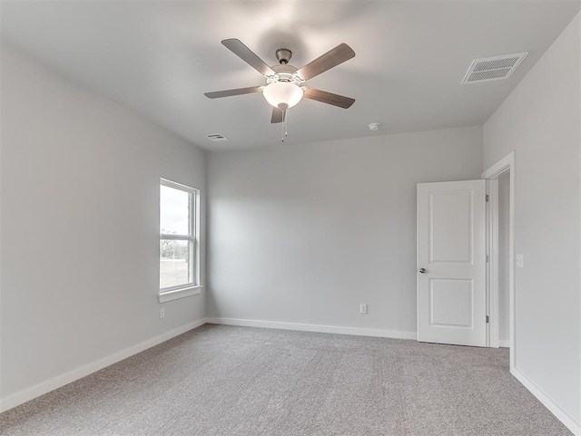 carpeted empty room featuring baseboards, visible vents, and ceiling fan