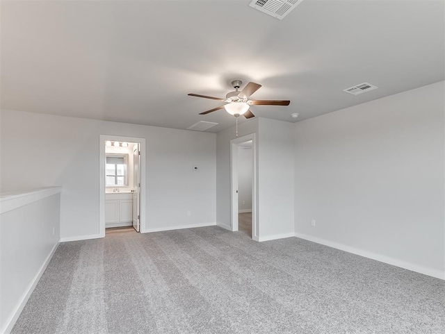 carpeted empty room featuring a ceiling fan, visible vents, and baseboards