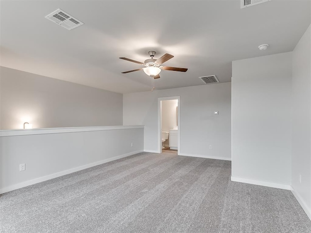 carpeted empty room with baseboards, visible vents, and ceiling fan