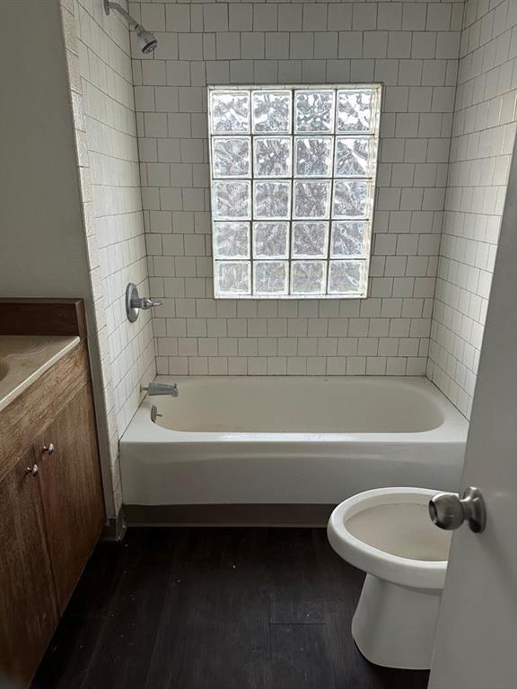 full bathroom featuring toilet, vanity, tiled shower / bath combo, and hardwood / wood-style flooring