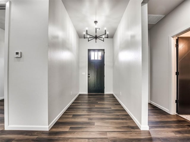 foyer with an inviting chandelier and dark hardwood / wood-style flooring