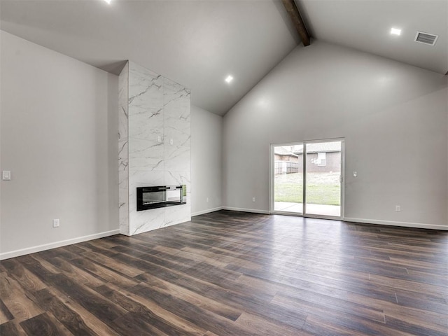 unfurnished living room featuring heating unit, a high end fireplace, dark wood-type flooring, high vaulted ceiling, and beam ceiling