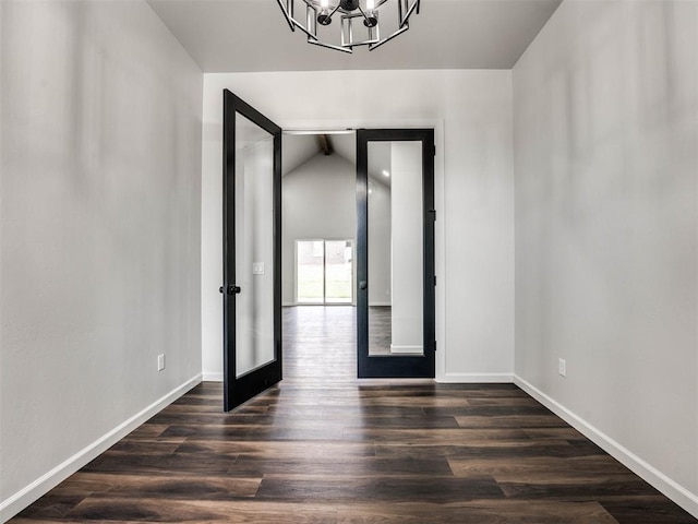 interior space with lofted ceiling, an inviting chandelier, french doors, and dark hardwood / wood-style floors