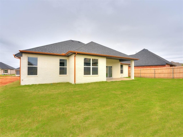 rear view of house with a yard and a patio area