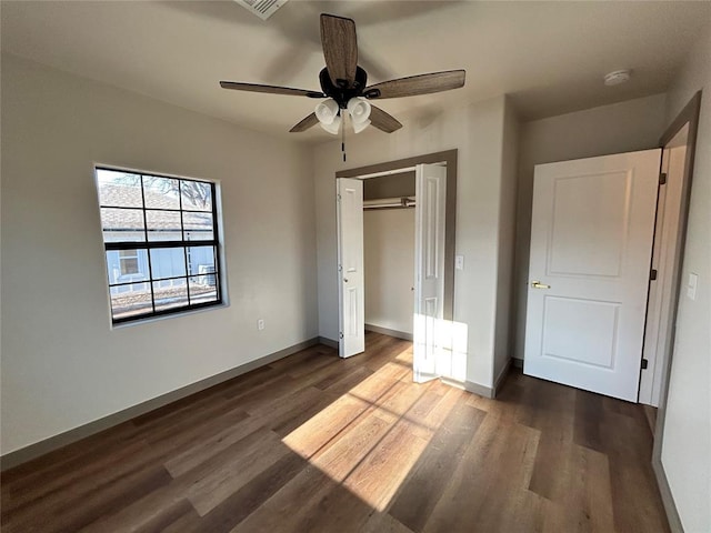 unfurnished bedroom featuring ceiling fan, dark wood-type flooring, and a closet