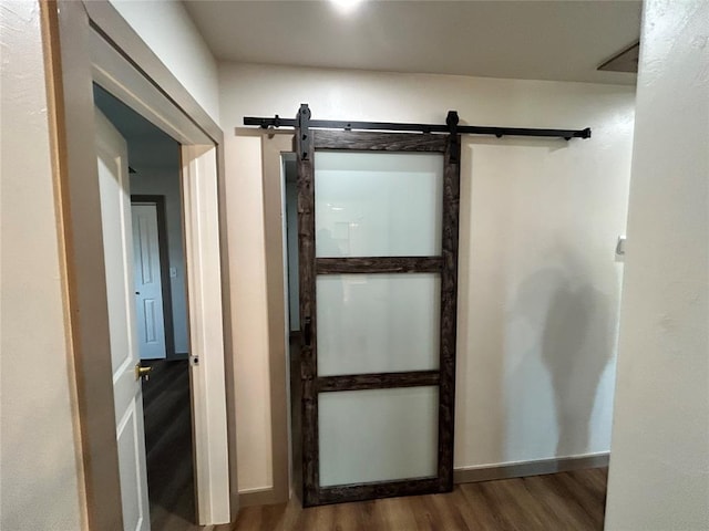 interior space with a barn door and wood-type flooring