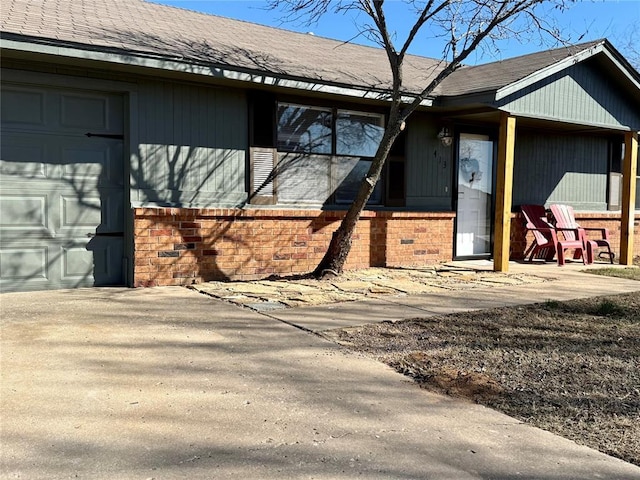 exterior space with brick siding and roof with shingles