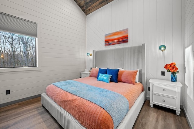 bedroom with vaulted ceiling, dark wood-type flooring, wooden walls, and wooden ceiling