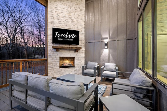 deck at dusk with an outdoor living space with a fireplace