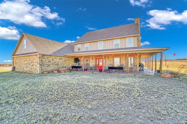 farmhouse inspired home featuring a patio and a front lawn