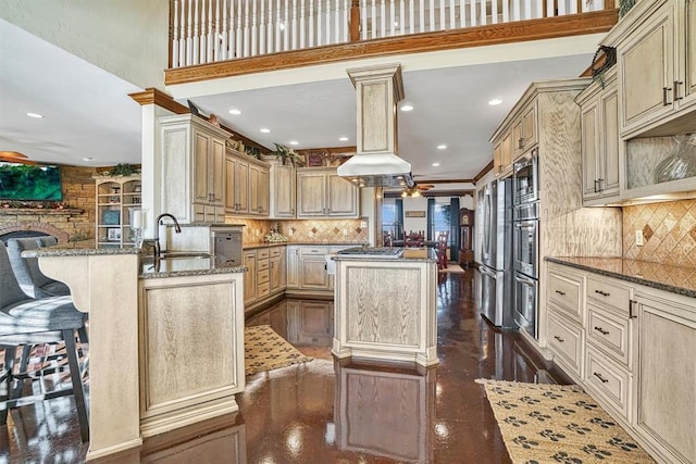 kitchen with a center island, a breakfast bar, kitchen peninsula, and sink