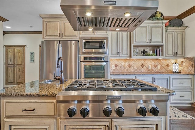 kitchen with extractor fan, appliances with stainless steel finishes, backsplash, dark stone counters, and cream cabinetry