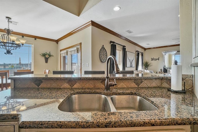 kitchen featuring pendant lighting, sink, a notable chandelier, and ornamental molding