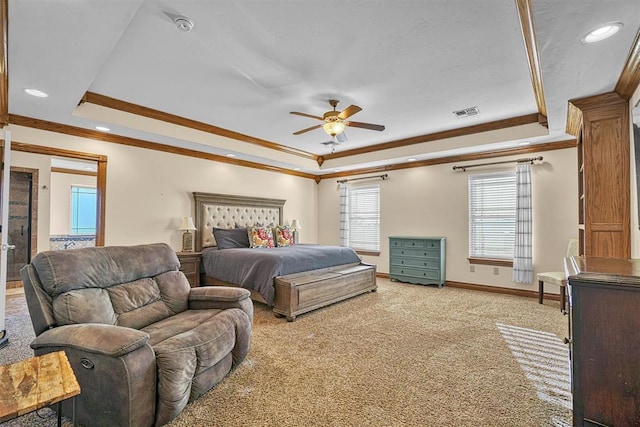 carpeted bedroom with a tray ceiling, ornamental molding, and ceiling fan