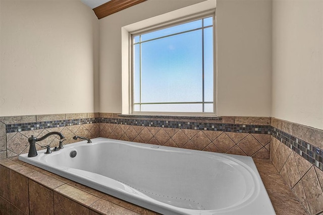 bathroom with a wealth of natural light and tiled bath