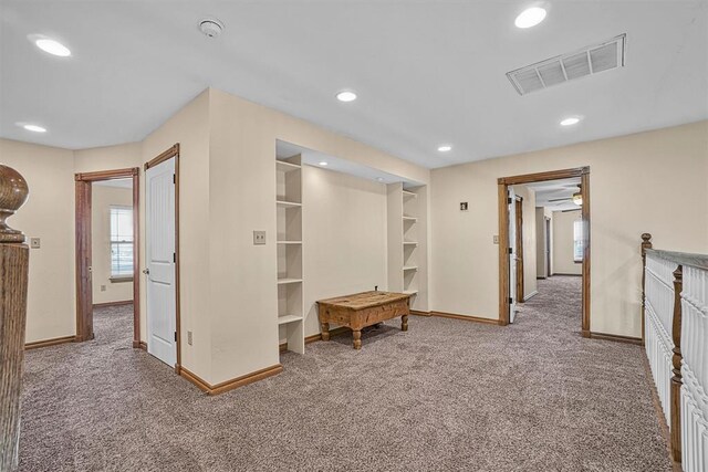 corridor featuring carpet and built in features