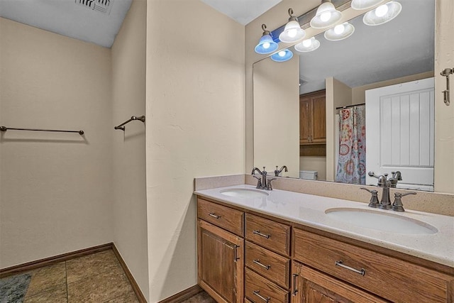 bathroom featuring vanity, tile patterned floors, and toilet