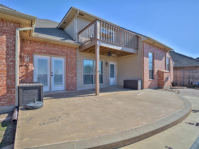 back of property featuring a balcony, a patio area, ceiling fan, and french doors