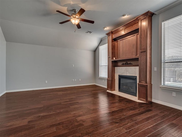 unfurnished living room featuring lofted ceiling, ceiling fan, dark hardwood / wood-style floors, and a tile fireplace