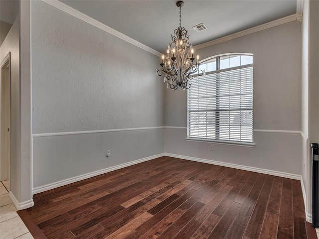 unfurnished room featuring hardwood / wood-style floors, ornamental molding, and an inviting chandelier