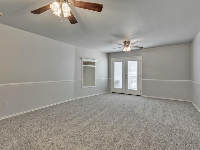 carpeted spare room featuring ceiling fan and french doors