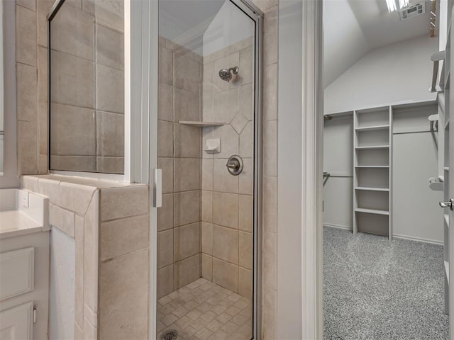 bathroom with vanity, lofted ceiling, and a shower with door