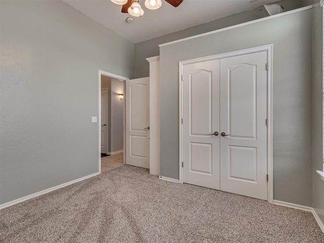 unfurnished bedroom with ceiling fan, a closet, and light carpet