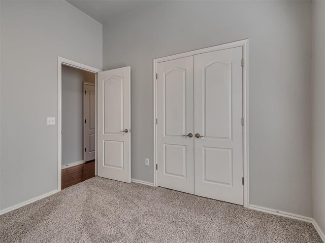 unfurnished bedroom featuring light colored carpet and a closet