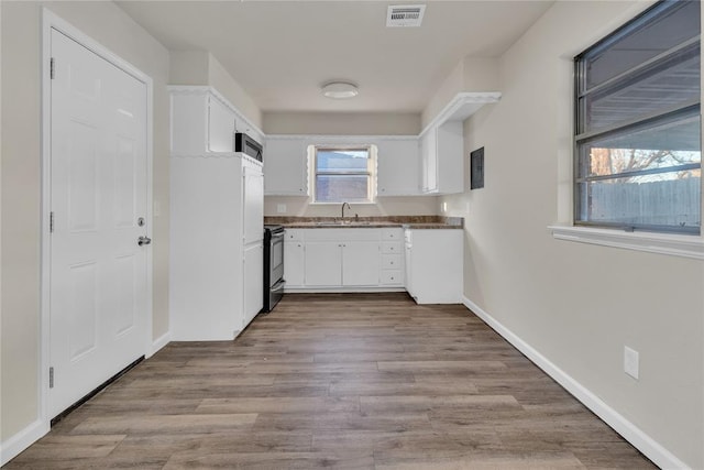 kitchen with sink, white cabinetry, a healthy amount of sunlight, and stainless steel range with electric cooktop