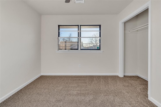 unfurnished bedroom featuring ceiling fan, a closet, and carpet flooring