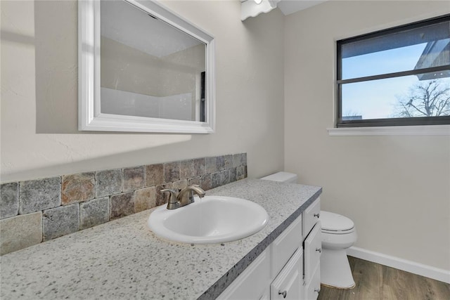 bathroom with toilet, vanity, tasteful backsplash, and hardwood / wood-style floors