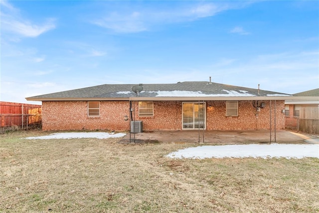 rear view of house with cooling unit, a lawn, and a patio