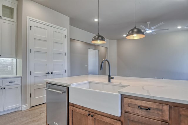 kitchen with pendant lighting, light stone countertops, white cabinetry, and ceiling fan