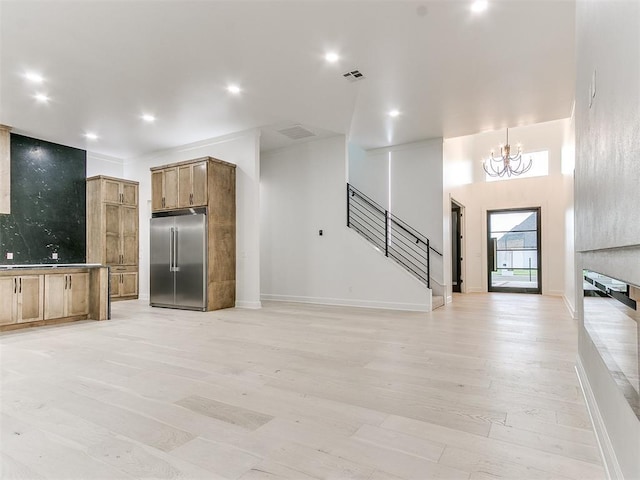 kitchen with stainless steel built in refrigerator, light wood-type flooring, and a chandelier