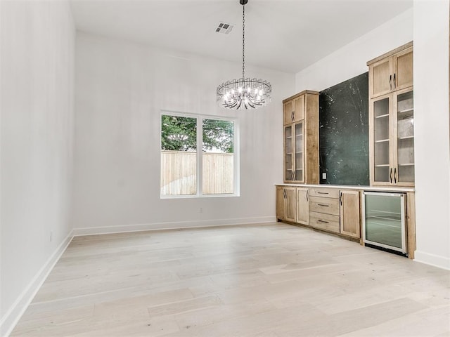 interior space with beverage cooler, an inviting chandelier, and light wood-type flooring