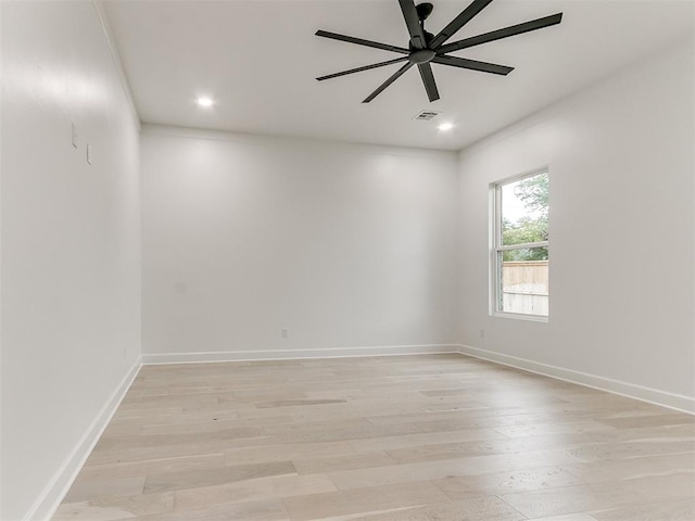 empty room with ceiling fan and light hardwood / wood-style flooring