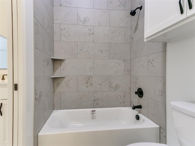 bathroom featuring toilet and tiled shower / bath