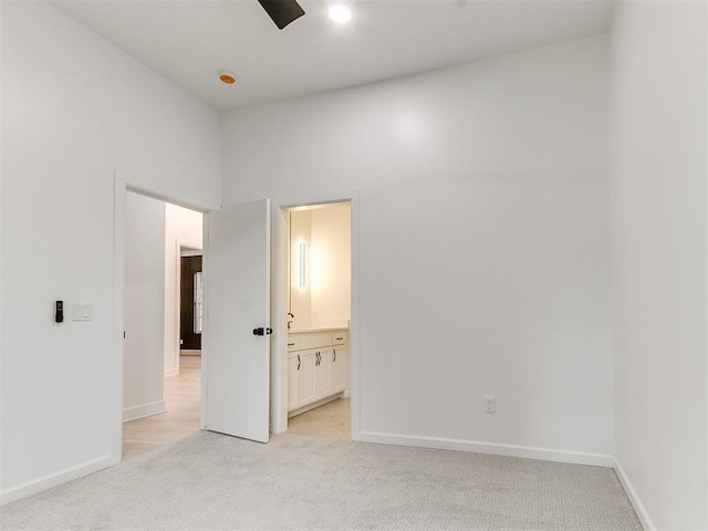 carpeted empty room featuring a high ceiling and ceiling fan