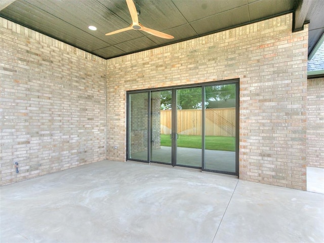 spare room featuring brick wall, concrete floors, and ceiling fan