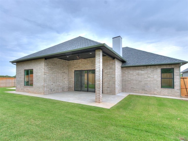 rear view of house with a lawn and a patio area