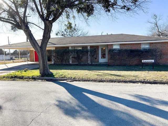 single story home with a front lawn and a carport