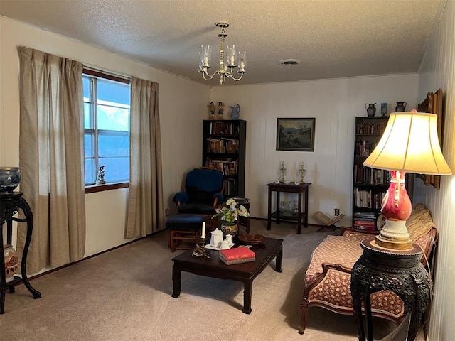 living area with a textured ceiling, a chandelier, and carpet flooring