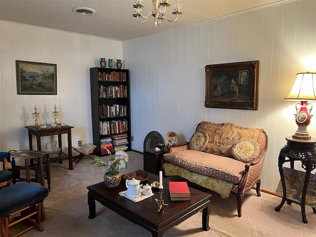 living area with carpet, a textured ceiling, and an inviting chandelier