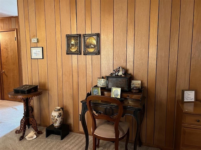 sitting room featuring carpet and wood walls