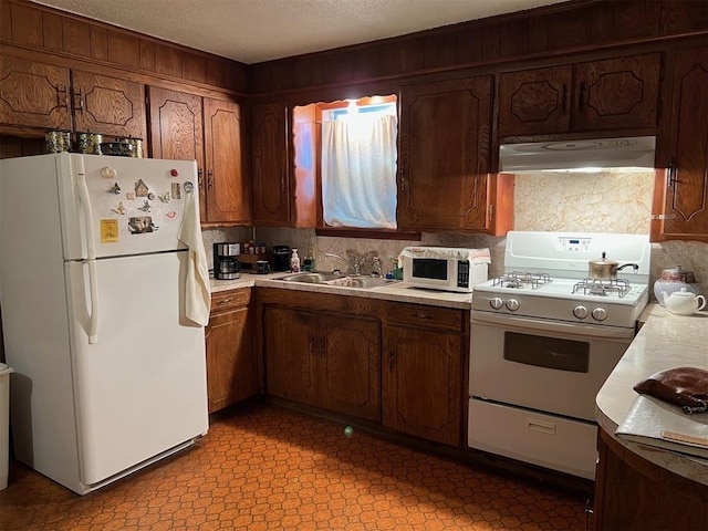 kitchen with sink, white appliances, a textured ceiling, and exhaust hood